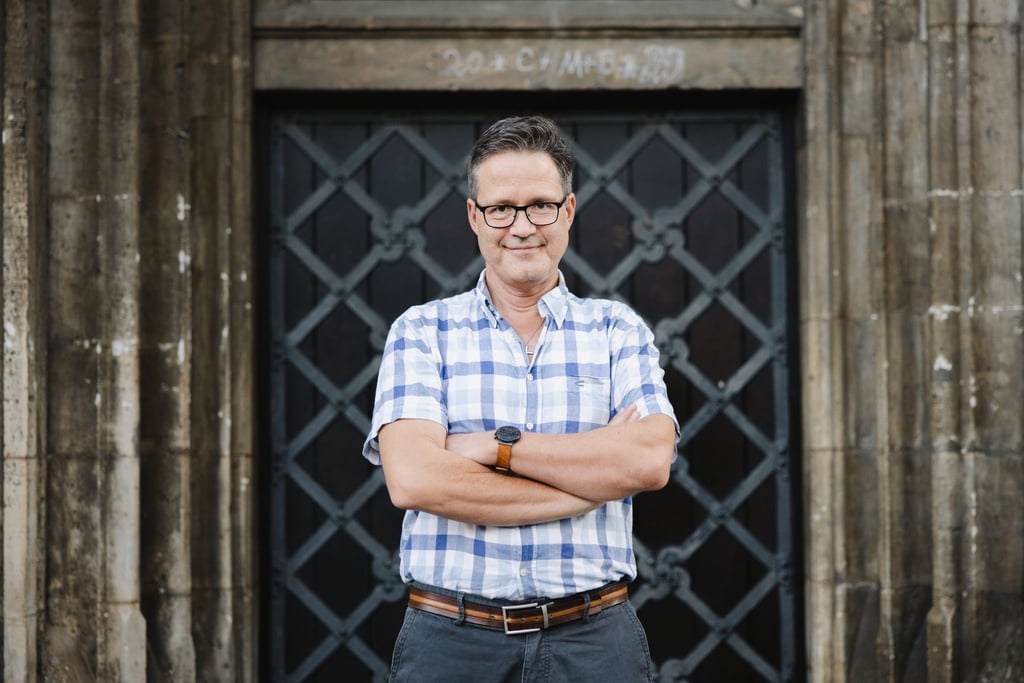 Gerd-Peter Münden steht vor dem Braunschweiger Dom.