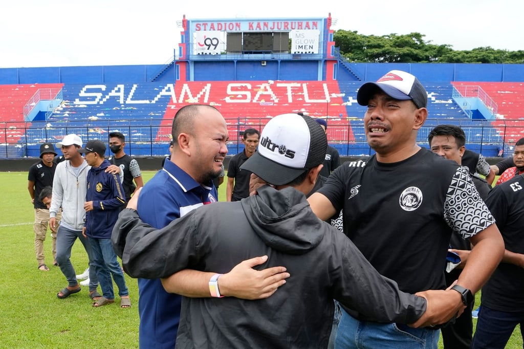 Fans und Offizielle des Arema FC umarmen sich nach einem Gebet im Kanjuruhan-Stadion, wo es zu einer Massenpanik kam.