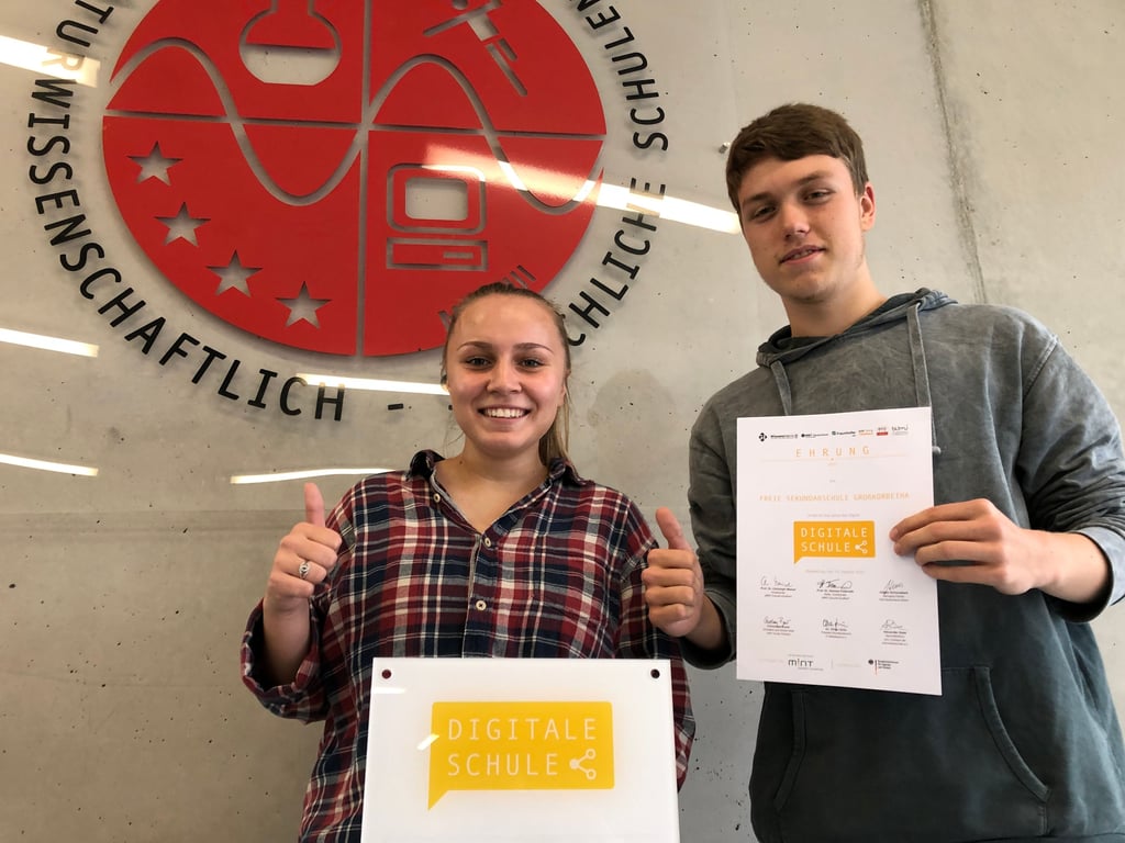 Aliyah Tiedtke und Jonah Schimpf zeigen stolz Logo und Urkunde.