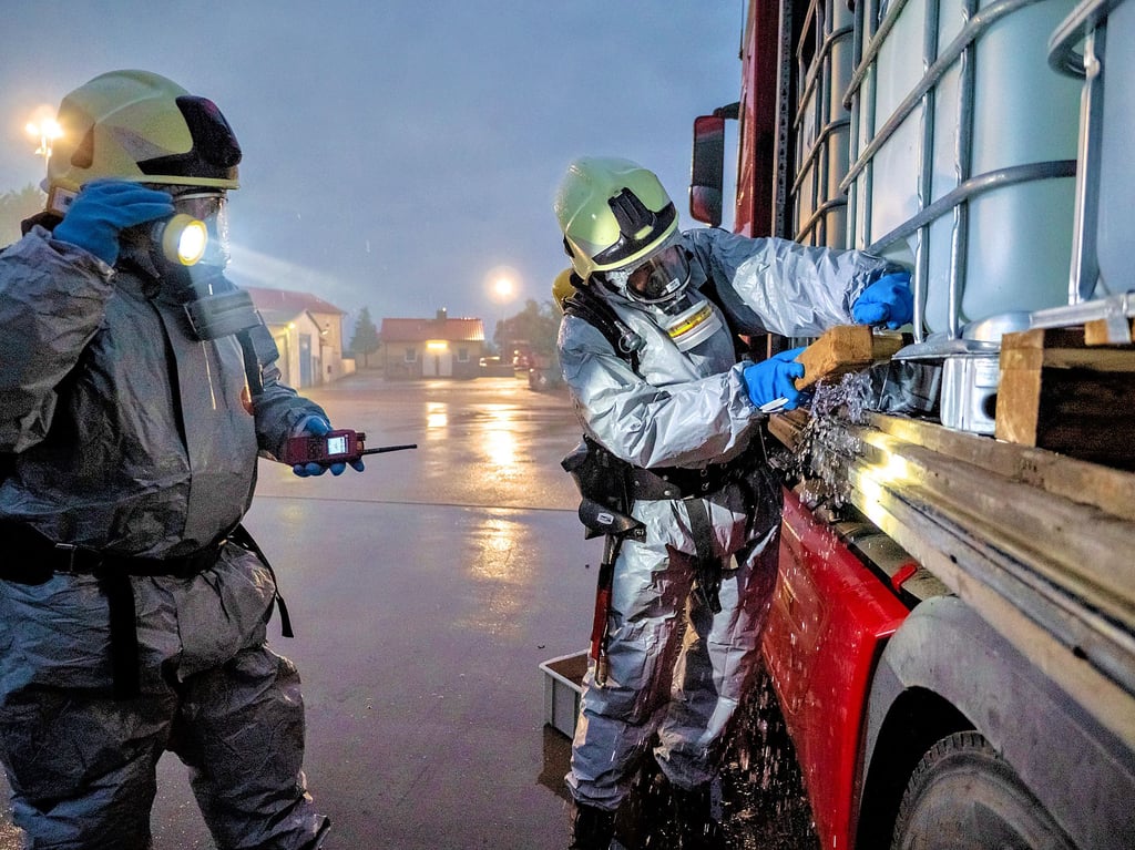 Kameraden der Leitzkauer Wehr dichten in Vollschutz den leckgeschlagenen Tank des Gefahrguttransports ab. Vergessen hingegen wurde seitens der Einsatzleitung, die Gullys abzudichten, um eine mögliche Umweltgefahr abzuwehren.