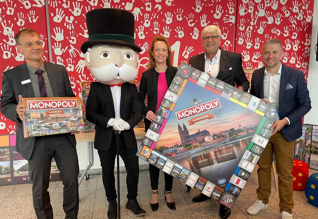 Ulf Holzapfel von der Sparkasse Magdeburg, das Monopoly-Maskottchen, Wirtschaftsbeigeordnete Sandra Yvonne Stieger, Pro M-Geschäftsführer Georg Bandarau und Florian Freitag vom Polar 1 (v. l.) bei der Präsentation des Magdeburger Monopoly-Spiels.