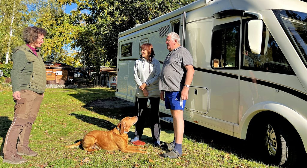 Martina und Norbert Wagner aus Mecklenburg-Vorpommern unterhalten sich vor ihrem Wohnmobil mit Ricarda Ringer vom Schönfelder Campingplatz. Wegen des schönen Wetters ist der Platz dieses Jahr recht lange gebucht.