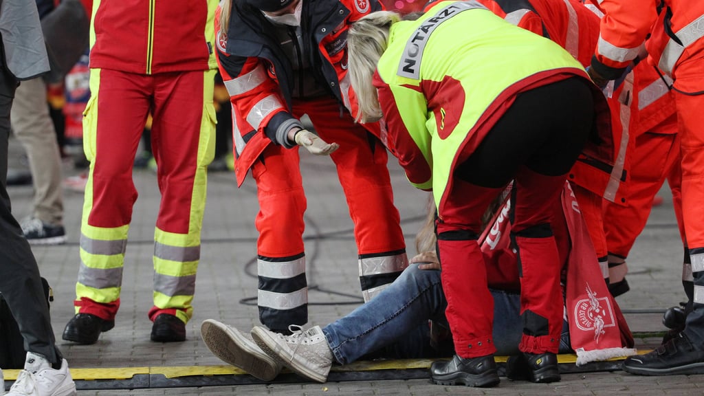 Sanitäter versorgen die ausgeknockte Frau in der Red Bull Arena.