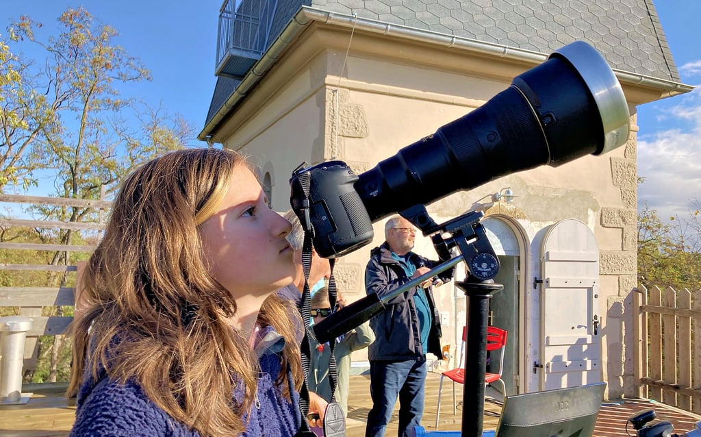 Die 13-jährige Hella beobachtet durch die Kamera, die vor dem Objektiv eine spezielle Folie hat, wie sich der Mond vor die Sonne schiebt.