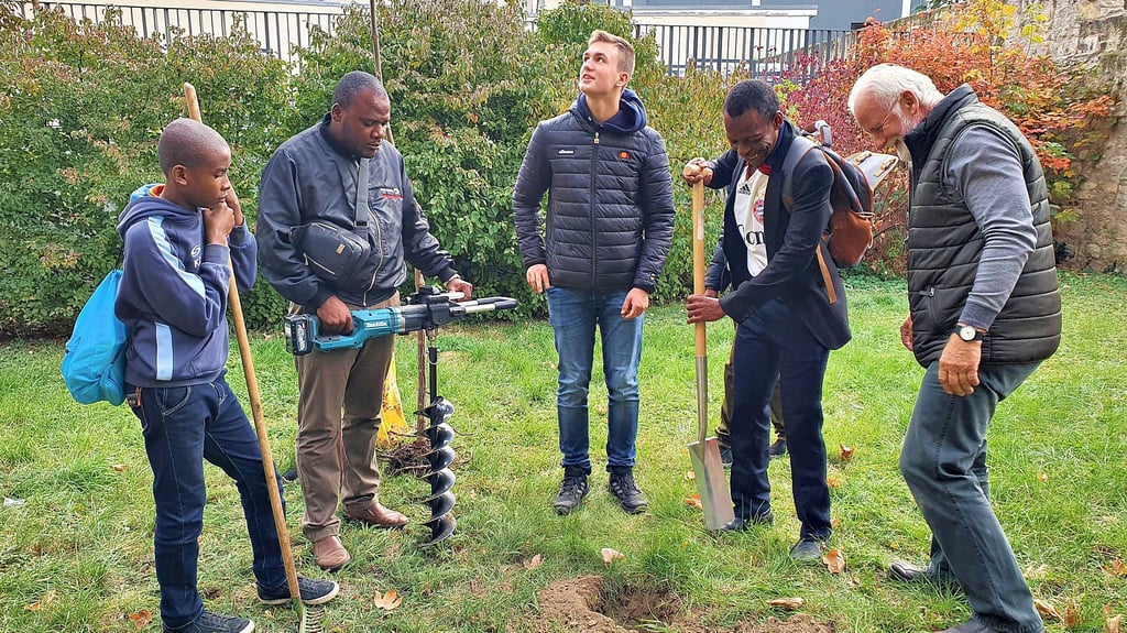 Frank Larisch (rechts) und Campus-Schüler Quentin Müller bereiten gemeinsam mit der Delegation aus Sansibar das Pflanzloch für den Paulownia-Baum vor.