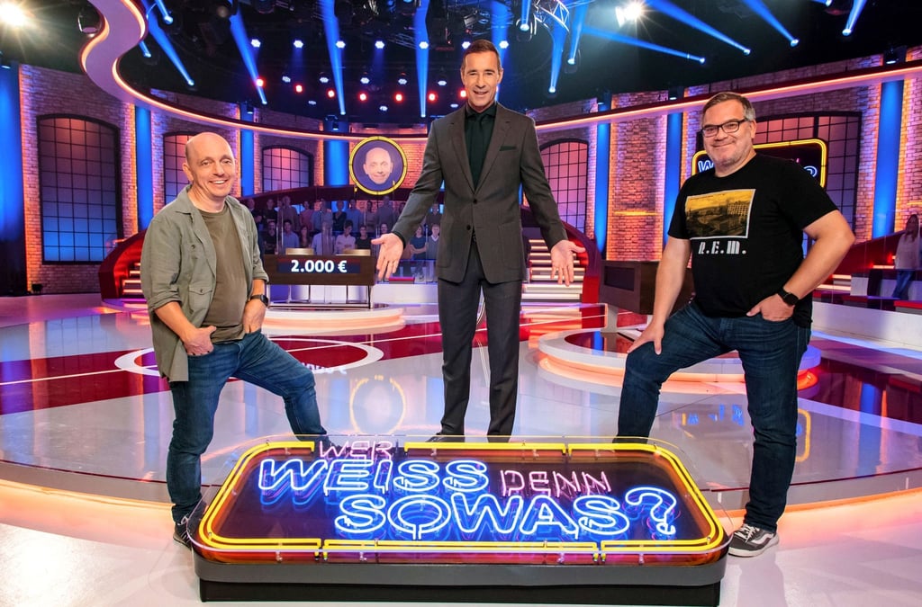 Moderator Kai Pflaume (M) neben Bernhard Hoëcker (l) und Elton: Die beiden Teamkapitäne werden bei „Wer weiß denn sowas?“ 25 Stunden ohne Pause versuchen, die richtigen Antworten auf Quizfragen zu finden.