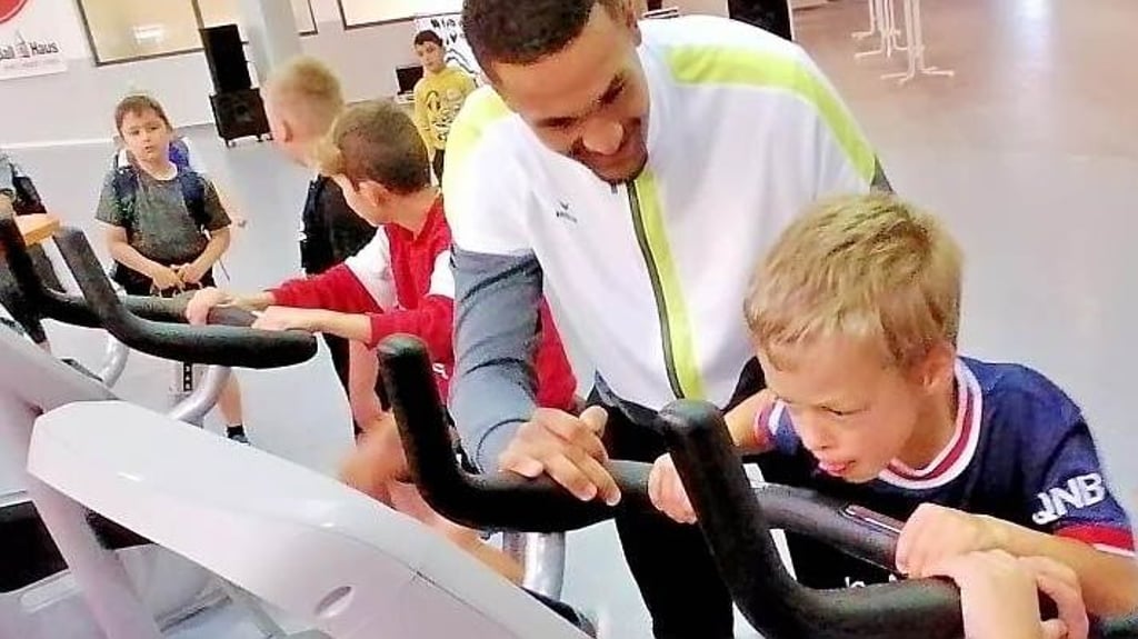 Beim 5. Bewegungstag der Jugendpflege erklärt Noah Litzbach von den Aschersleben Tigers die Regeln des Ergometer-Wettkampfes. Zu gewinnen gibt es Gutscheine für das Fitnessstudio im Ballhaus.