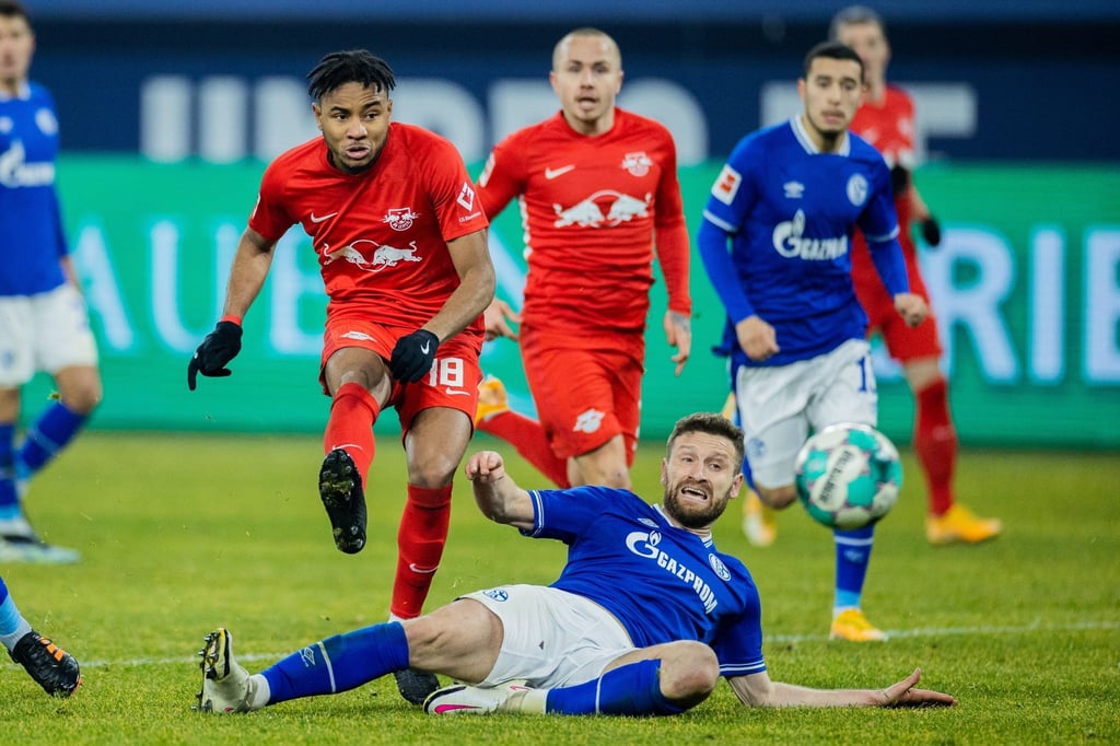 Schalkes Shkodran Mustafi kann den Schuss von Leipzigs Christopher Nkunku (l) nicht verhindern.