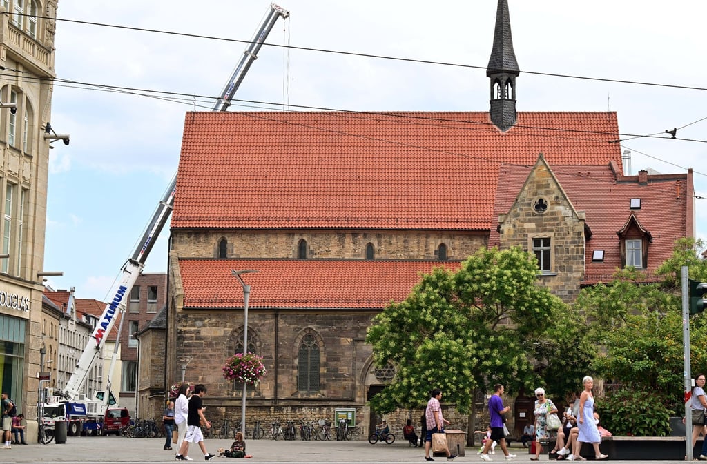 Am historischen Ursulinenkloster in der Erfurter Innenstadt wird ein Unterdreh-Kran in den Chorgarten des Klosters gehoben.