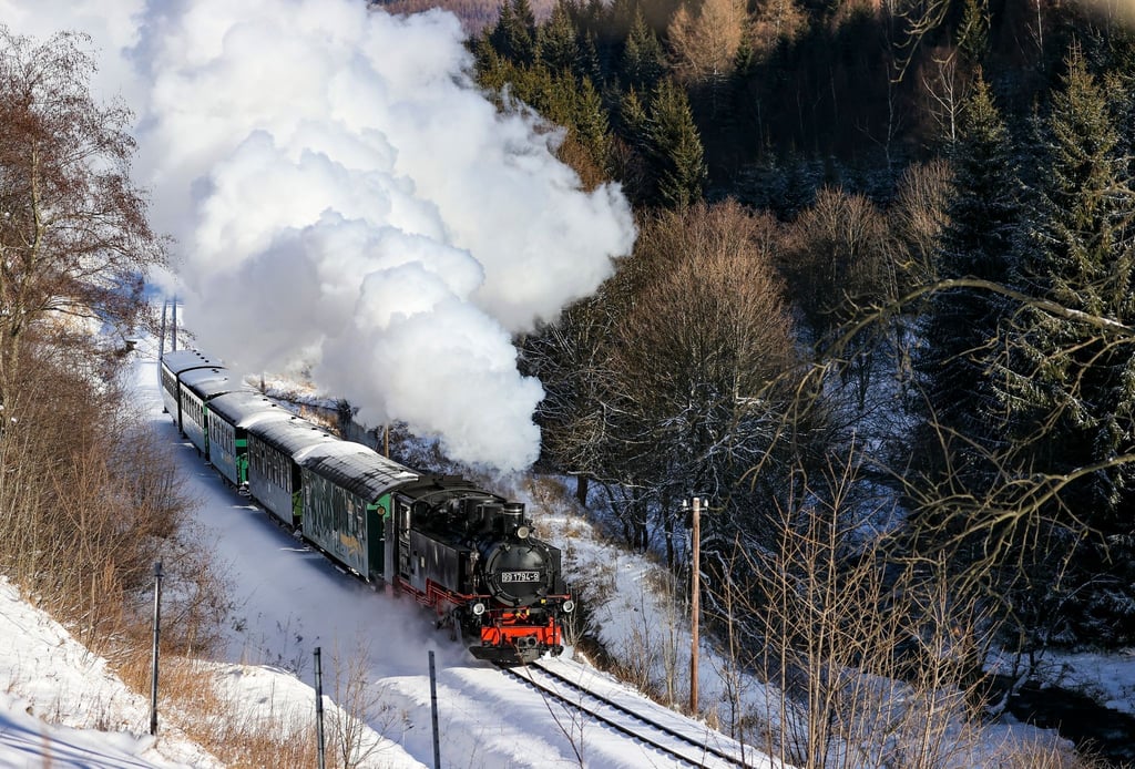Die Fichtelbergbahn schnauft im Januar durch den Winterwald im Erzgebirge.