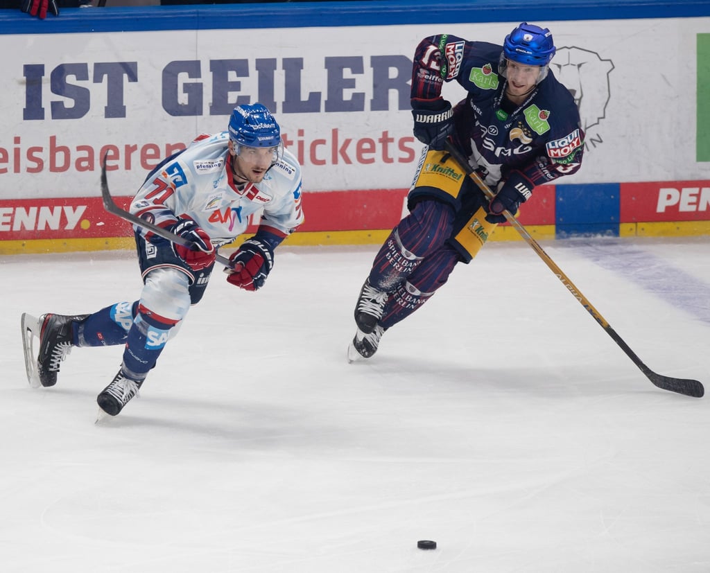 Mannheims Borna Rendulic (l) und Berlins Peter Regin jagen den Puck nach.