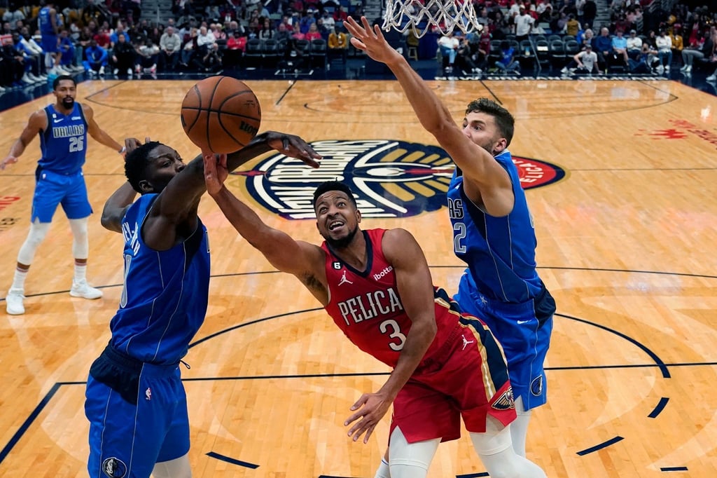 New Orleans Pelicans-Guard CJ McCollum (3) in Aktion mit den Dallas Mavericks-Forwards Dorian Finney-Smith (l) und Maxi Kleber (r).