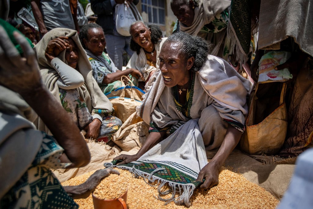 Eine äthiopische Frau streitet mit anderen über die Verteilung von gelben Spalterbsen, nachdem diese von einer Hilfsorganisation in der Region Tigray verteilt worden waren.