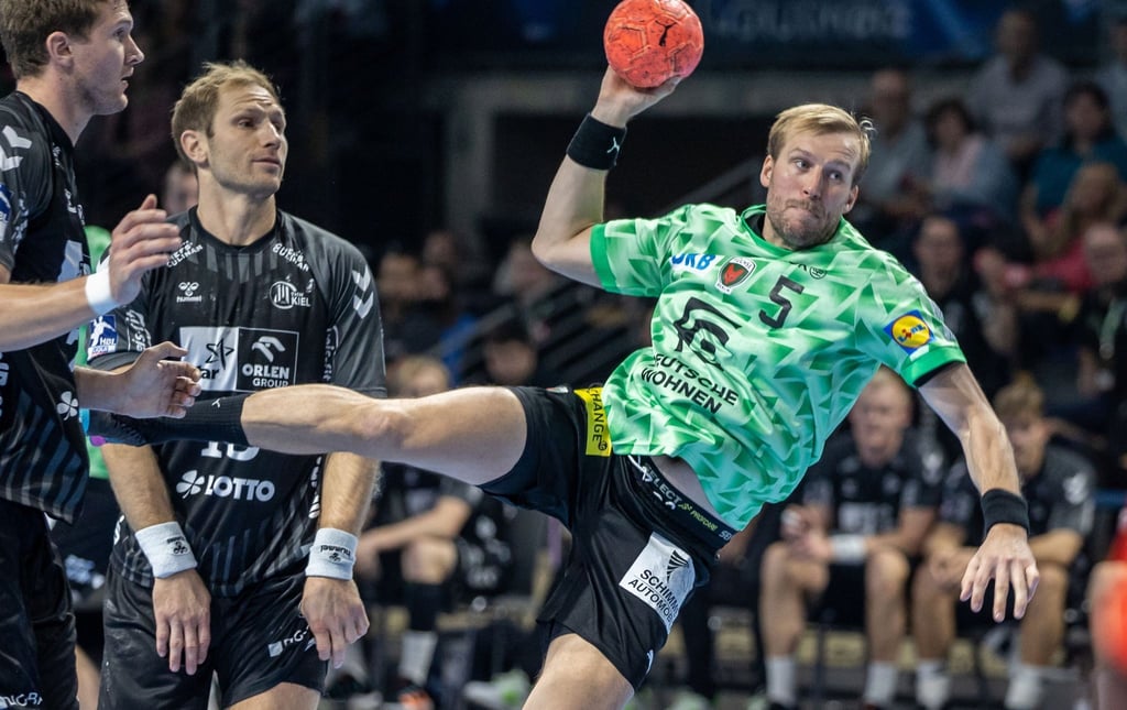 Berlins Max Darj (r) wirft den Ball auf das Tor neben Steffen Weinhold von THW Kiel.