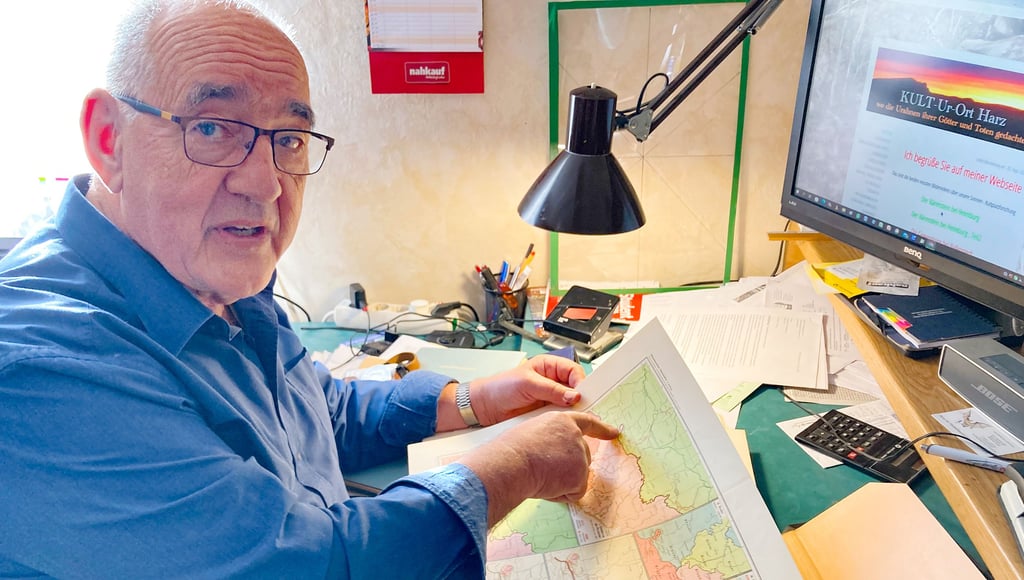 Werner Körner vom Verein für Heimatgeschichte in Westerhausen mit einem Atlas, der auf einer Karte die Mundartbereich aufzeigt.