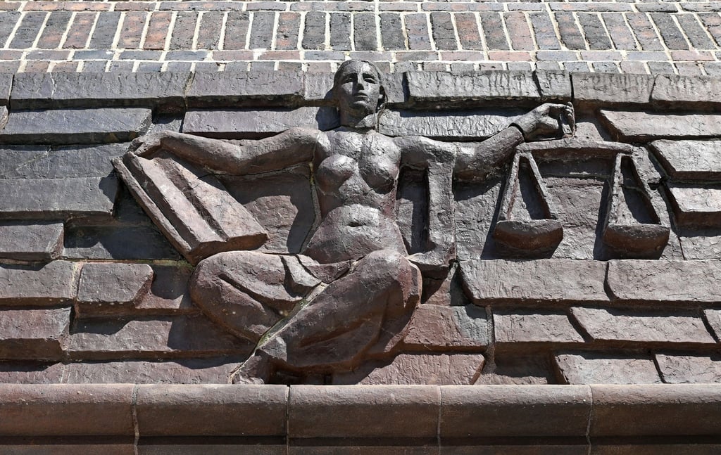 Blick auf die Justitia über dem Eingang eines Landgerichts.