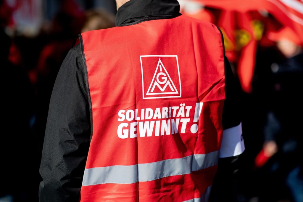 Ein Teilnehmer einer Kundgebung der IG Metall trägt eine rote Weste mit der Aufschrift „Solidarität gewinnt!“.