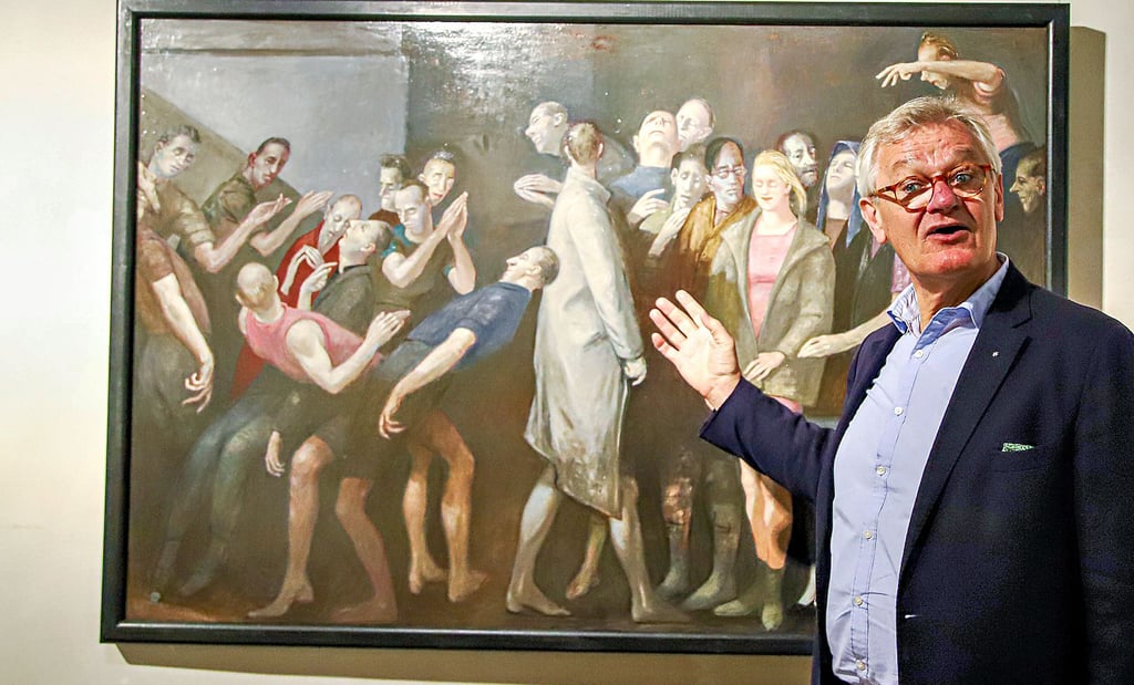 Stiftungsvorsitzender Christhard-Georg Neubert zeigt auf ein Gemälde des Künstlers Volker Stelzmann, das derzeit in der Stiftung Christliche Kunst im Wittenberger Schloss zu sehen ist – und viele Interpretationsmöglichkeiten bietet.