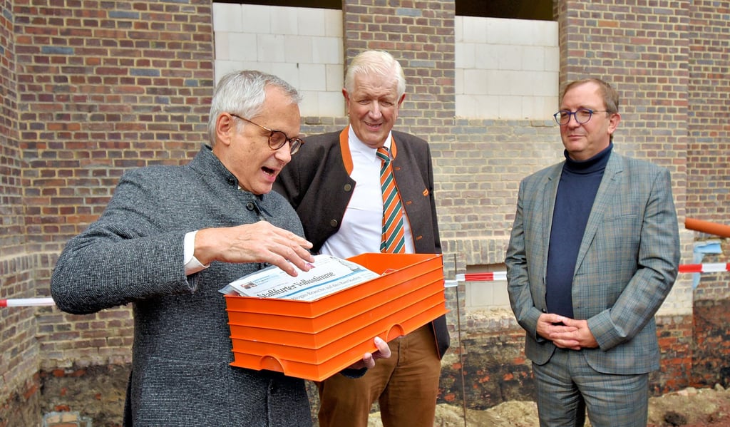 Im Grundstein für das Egelner Seniorenheim hat Architekt Johannes Krause, hier mit Burchard Führer und Landrat Markus Bauer (r.), nicht nur Münzen, Visitenkarten der Teilnehmer, eine Zeichnung vom Haus und Wein, sondern auch die tagesaktuelle Staßfurter Volksstimme verstaut.