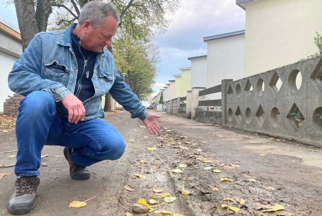 Michael Block zeigt auf die nicht fachgerecht verfüllten Gräben, die die Straßen in Bernburg-Zickzackhausen in den vergangenen Wochen in Schlammlandschaften verwandelten