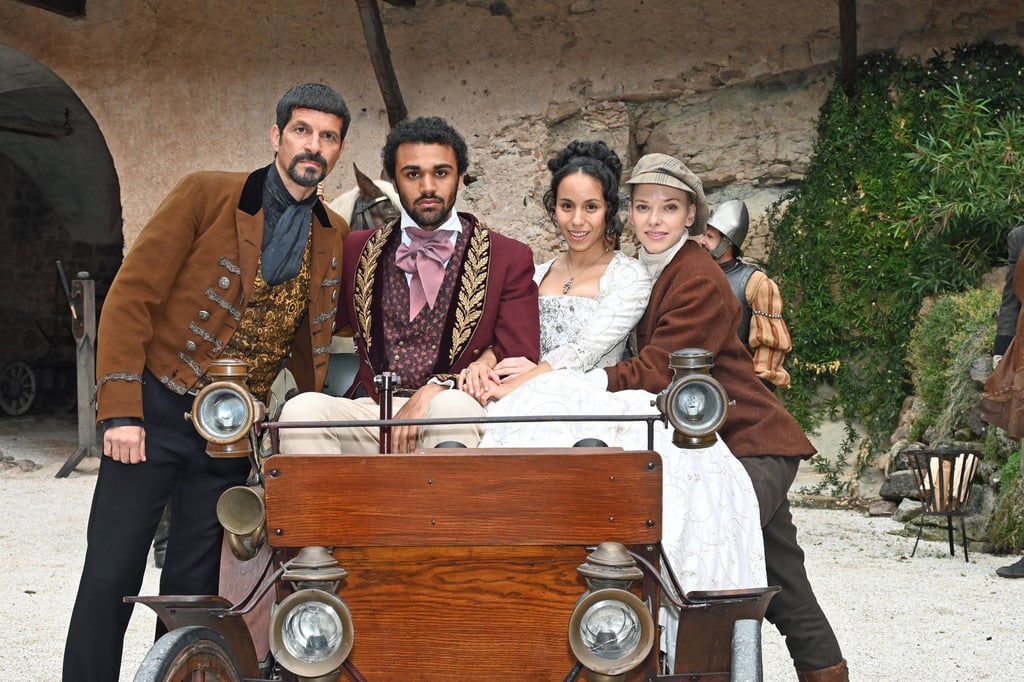 Die Schauspieler und Schauspielerinnen Pasquale Aleardi (Fürst Rudolf, l-r), Langston Uibel (Rudolph), Kristin Alia Hunold (Sophia) und Judith Neumann (Melisa) lächeln während einer Drehpause beim Film „Die verkaufte Prinzessin“.