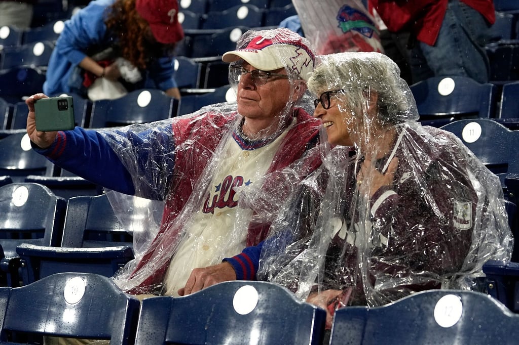 Fans in Regenponchos machen im Citizens Bank Park vor Spiel drei ein Selfie.
