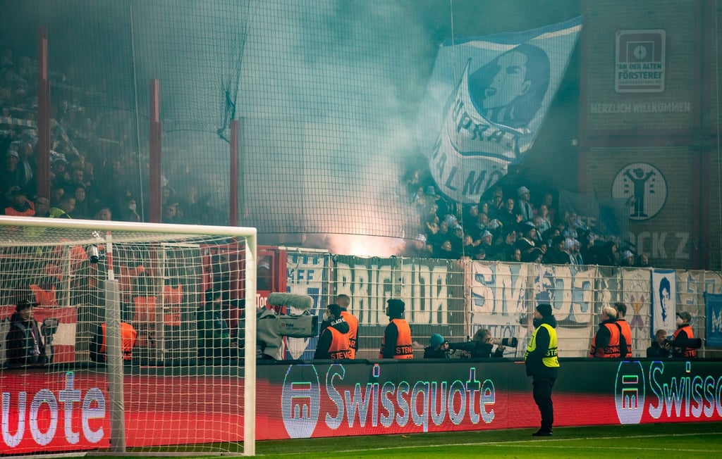 Fans von Malmö FF brennen Bengalische Feuer ab.