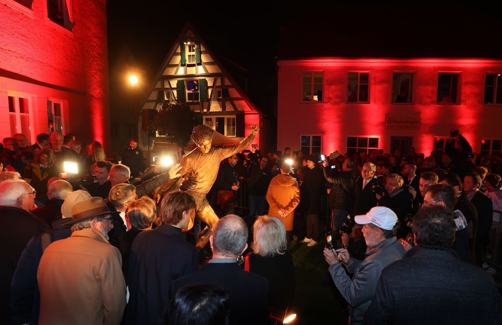 Zahlreiche Menschen umringen die frisch enthüllte Gerd-Müller-Statue in Nördlingen.
