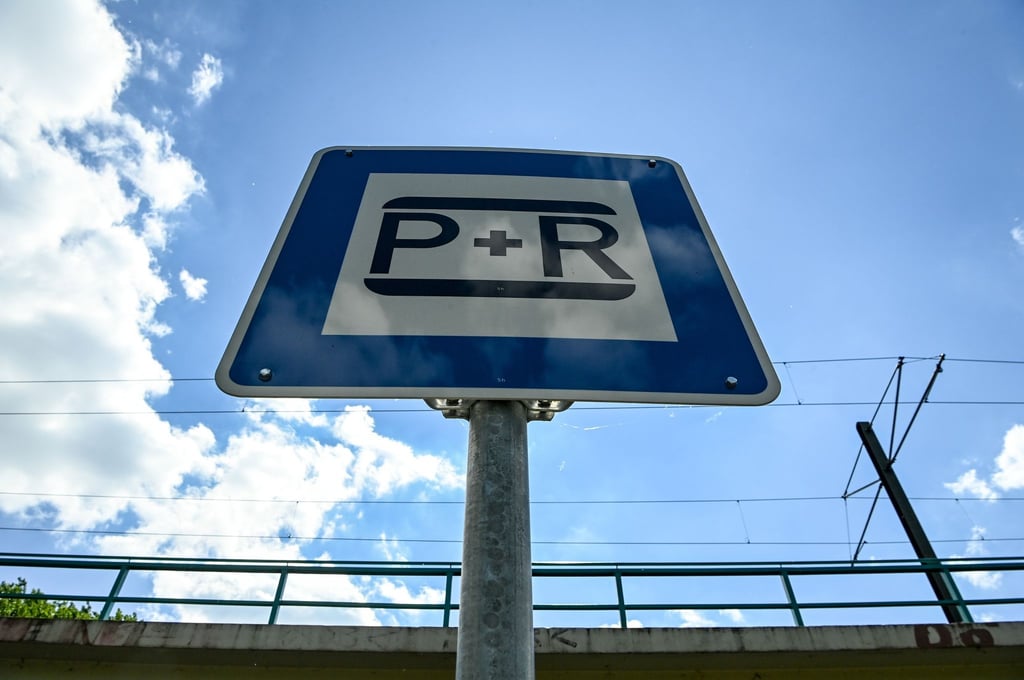 Ein Schild mit der Aufschrift „P+R“ steht auf einem Parkplatz.