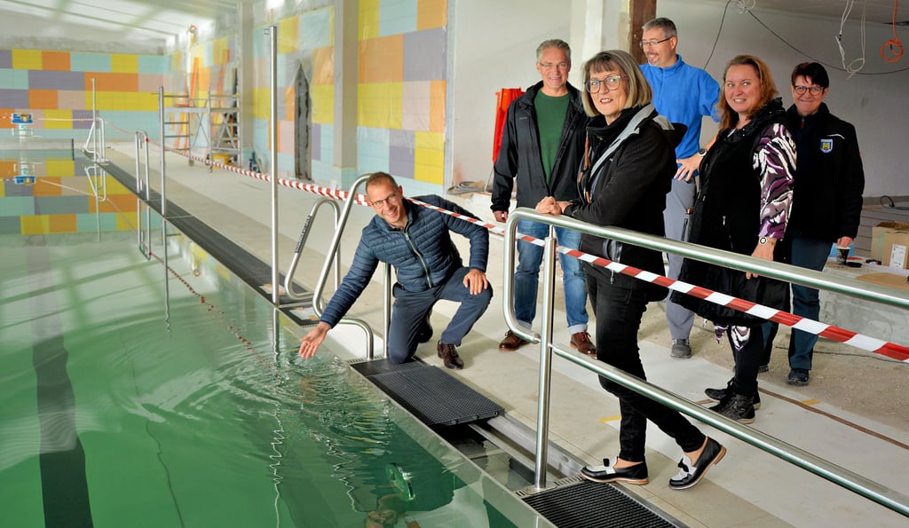 Bürgermeister Philipp Stark (links) am Rand des neuen Edelstahlbeckens, das bereits mit Wasser gefüllt ist und die Dichtheitsprüfung überstanden hat. Mit dabei Mitarbeiter der Stadt.