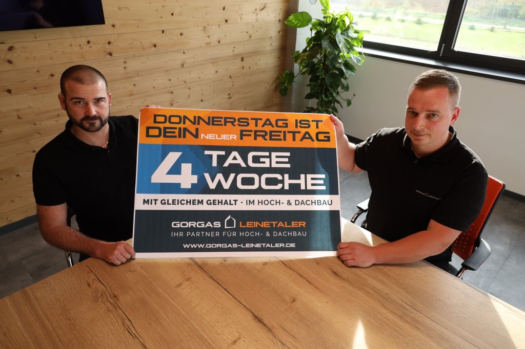 Maik Gorgas und Dustin Lichtenecker (v.l.) von der Dachdeckerei Gorgas und Leinetaler Hochbau führen die Vier-Tage-Woche ein. Mit dem Plakat wollen sie in der Stadt werben und neue Mitarbeiter gewinnen.