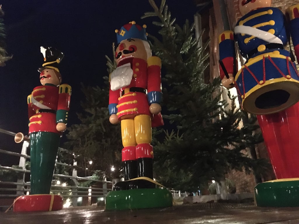 Von der Außenterrasse der Brauerei blicken diese riesigen Holzfiguren über Schulzens Hof auf das Adventsgetümmel.