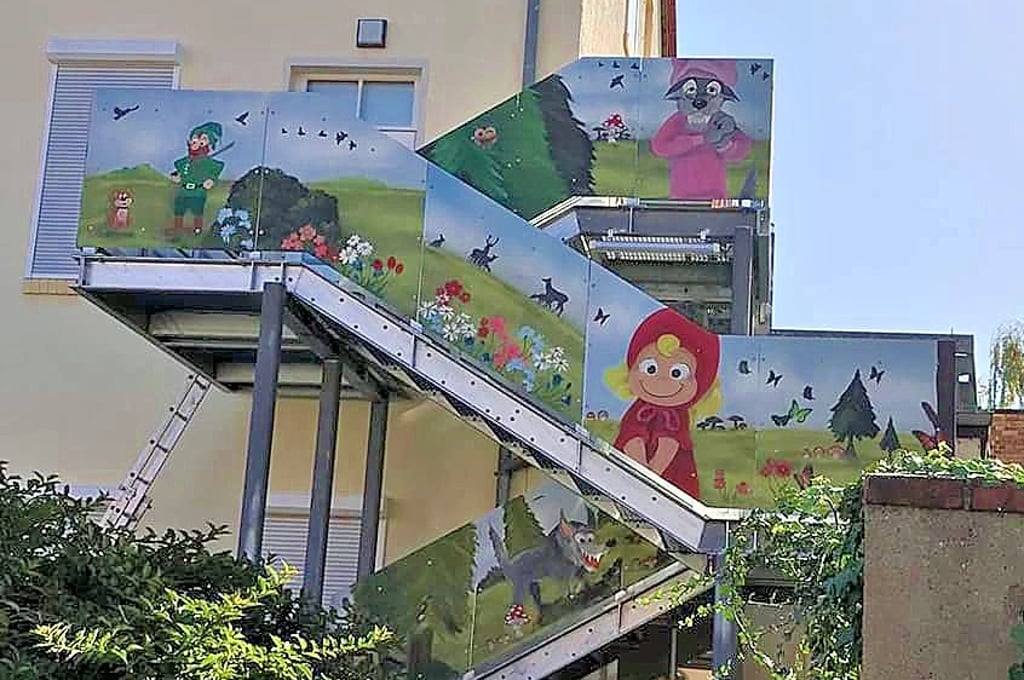 Die einst schmucklose Rettungstreppe der Kita hat Ronny Claus mit Figuren aus dem Märchen Rotkäppchen bemalt.