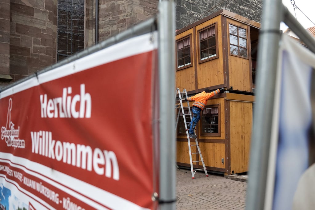 Ein Schaustellerwagen wird hinter einem Bauzaun für den Göttinger Weihnachtsmarkt aufgebaut.