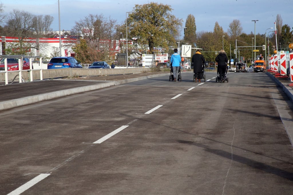 Frauen mit Kinderwagen gehen über die neue Asphaltdecke.