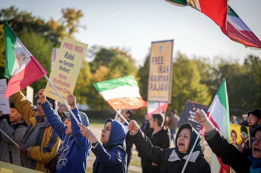 Teilnehmer demonstrieren für Freiheit und Demokratie im Iran vor dem Reichstagsgebäude.