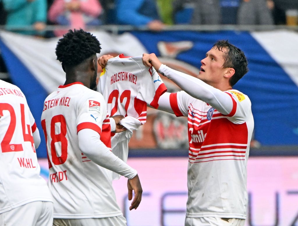 Die Kieler Kwasi Okyere Wriedt (l) und Torschütze Fabian Reese bejubeln den Treffer zum 3:0 gegen den KSC.