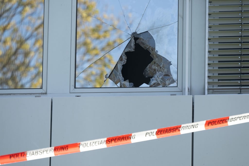 Ein Absperrband hängt vor einer zerbrochenen Fensterscheibe einer geplanten Flüchtlingsunterkunft.