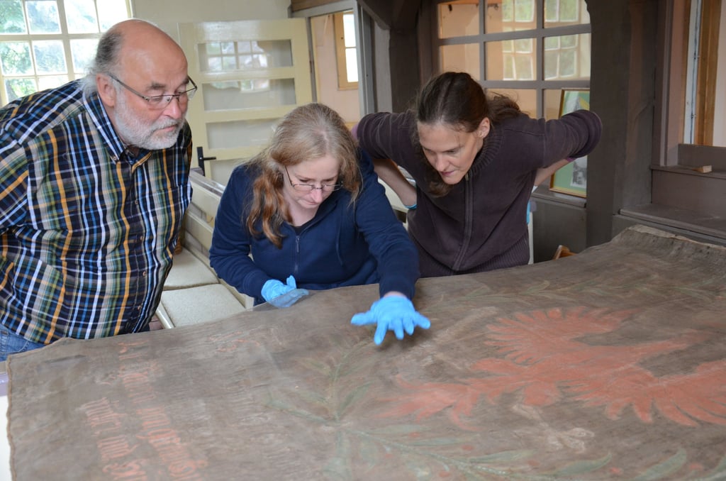 2015 begutachteten Textilrestauratorin Andrea Knüpfer (von rechts) und Gemälderestauratorin Andrea Himpel gemeinsam mit Andreas Finger die Dannefelder Bauernfahne von 1675.