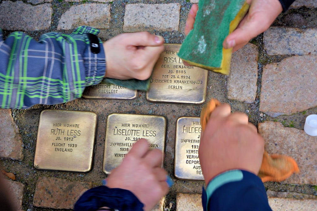 Gymnasiasten putzten am Mittwoch Stolpersteine vor dem früheren Schuhgeschäft der jüdischen Familie Less in Osterburg.