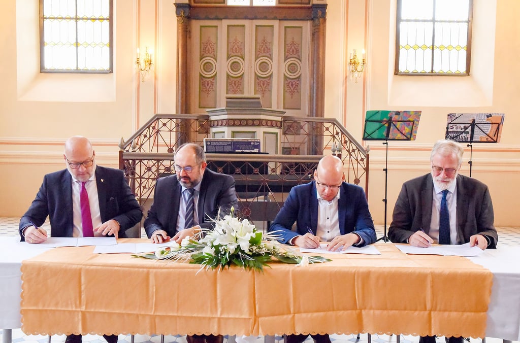 Bernhard Böddeker (Museumsverein), Thomas Schneider (Stadt Südliches Anhalt), Volker Krüger (stellv. Landrat) und Rainer Robra unterschreiben.