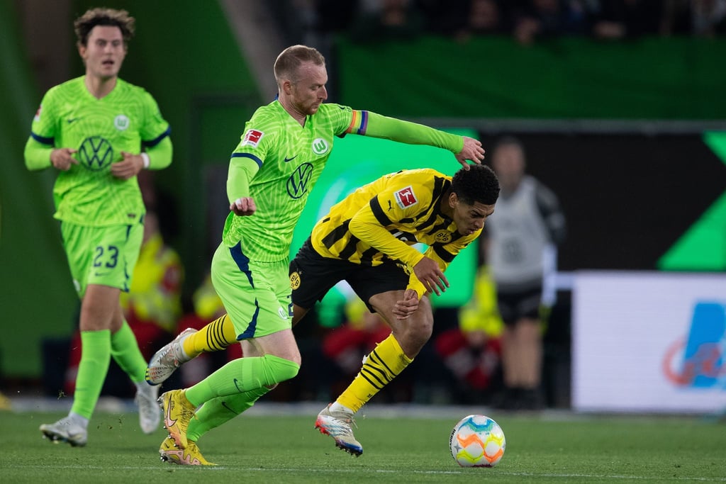 Wolfsburgs Maximilian Arnold (M) im Duell mit Dortmunds Jude Bellingham.