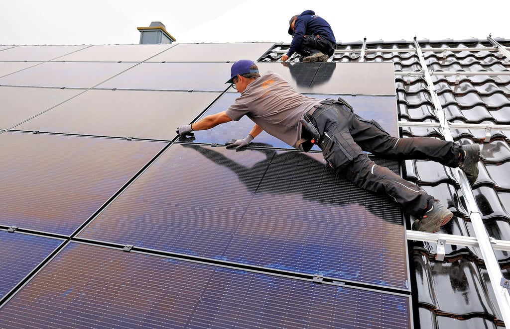 Montage einer Solaranlage auf einem Wohnhaus. Bevor Aufträge vergeben werden, sollten Hausbesitzer genau prüfen.