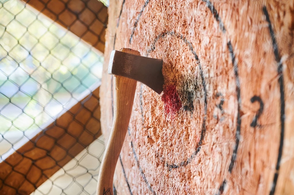 Eine Axt, geworfen von Jim Barker, Axe Master im Wood Cutter Berlin, steckt in eine Holzscheibe.