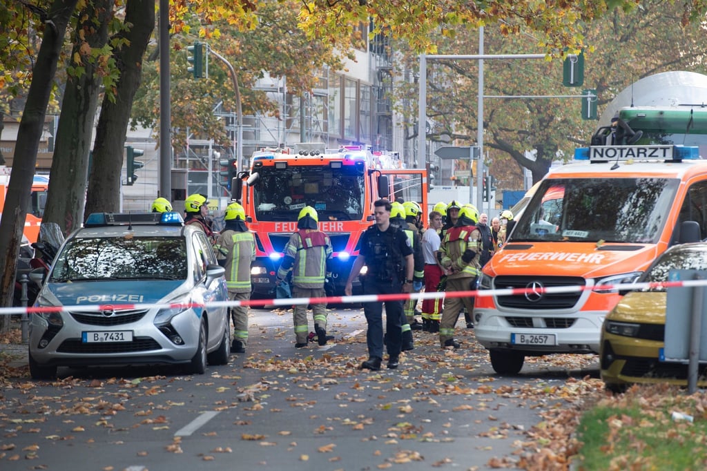 Einsatzkräfte von Polizei und Feuerwehr stehen auf der Straße.