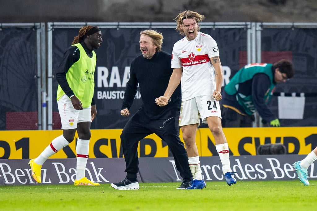Stuttgarts Sportdirektor Sven Mislintat (M) und Borna Sosa (r) jubeln nach dem späten Tor zum 2:1 gegen Hertha BSC.