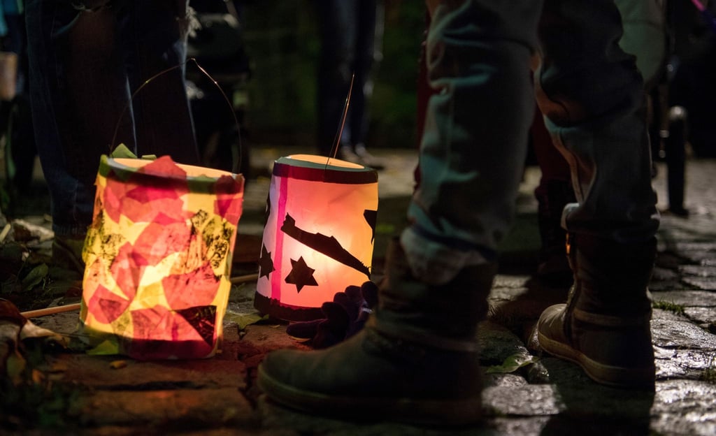 Laternen stehen bei einem Martinsumzug auf dem Boden.
