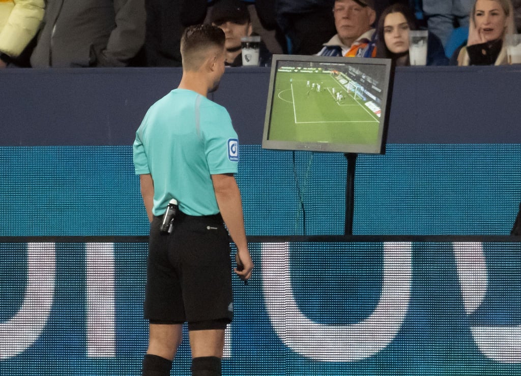Schiedsrichter Daniel Schlager schaut sich eine Szene auf einem Monitor an und gibt anschliessend einen Gladbacher Treffer nicht.