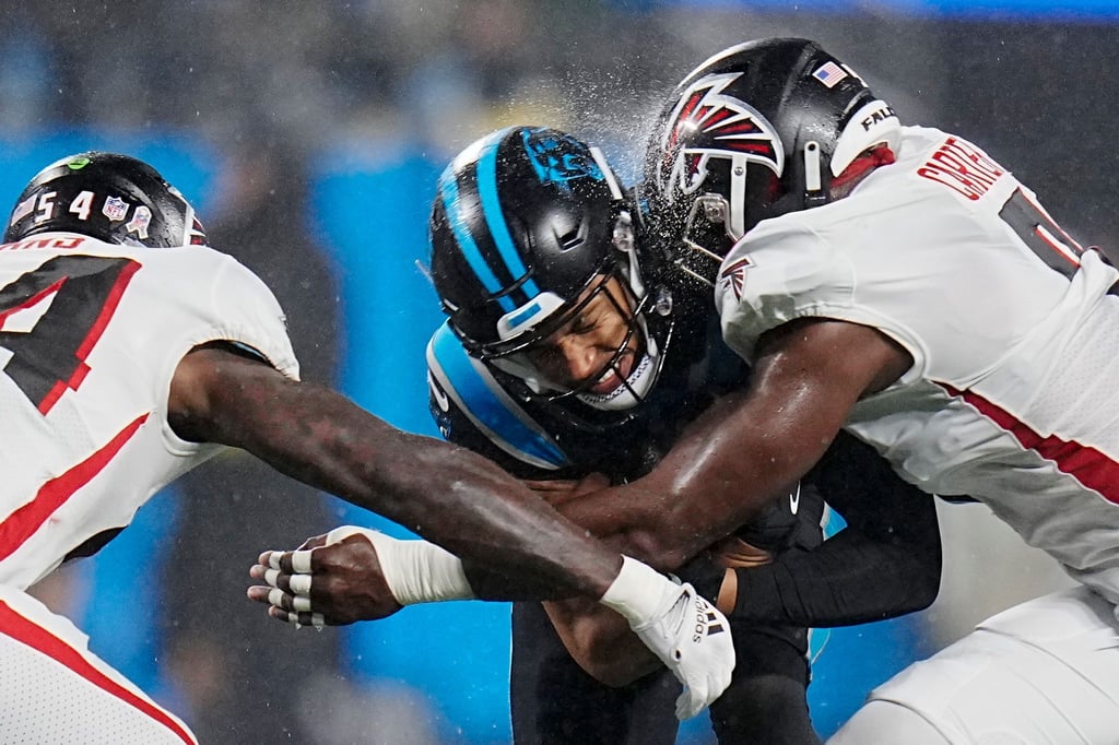 Carolina Panthers Chuba Hubbard (M) wird von Atlanta Falcons Rashaan Evans (l) und Lorenzo Carter angegriffen.