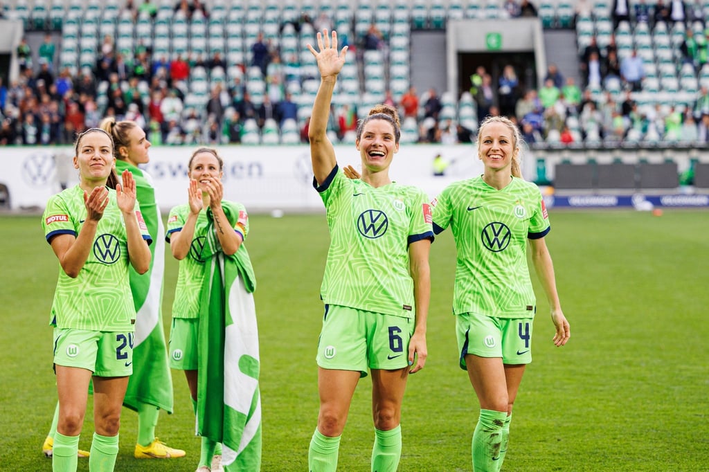 Wolfsburgs Spielerinnen Marie-Joelle Wedemeyer (l), Svenja Huth (3.v.l.), Dominique Janssen (2.v.r.) und Kathrin-Julia Hendrich (r) applaudieren und winken nach Spielende.
